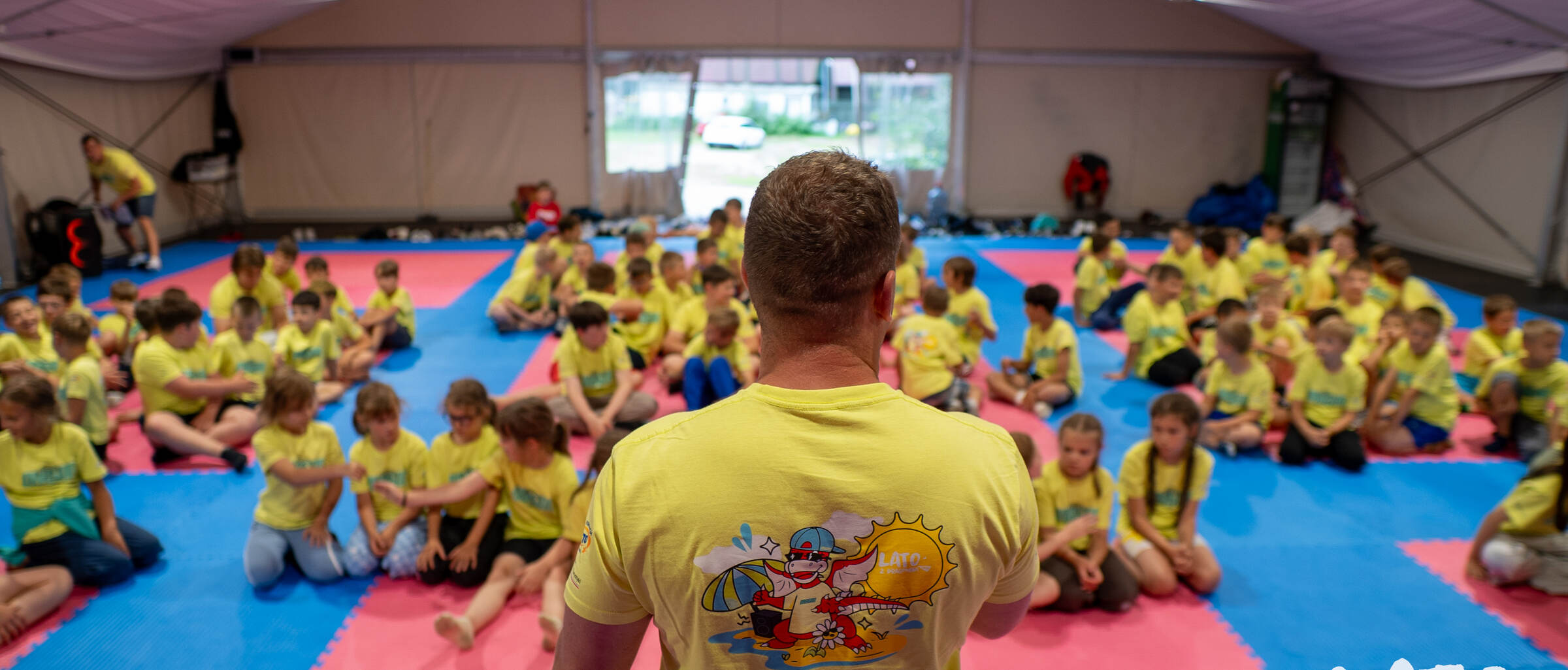 Uczestnicy obozu Judo Dragon na macie w namiocie treningowym